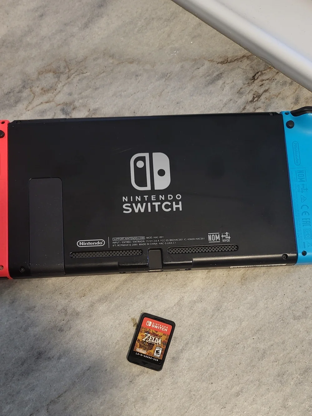 Nintendo Switch Console with Red Joy-Con and Zelda Game Card